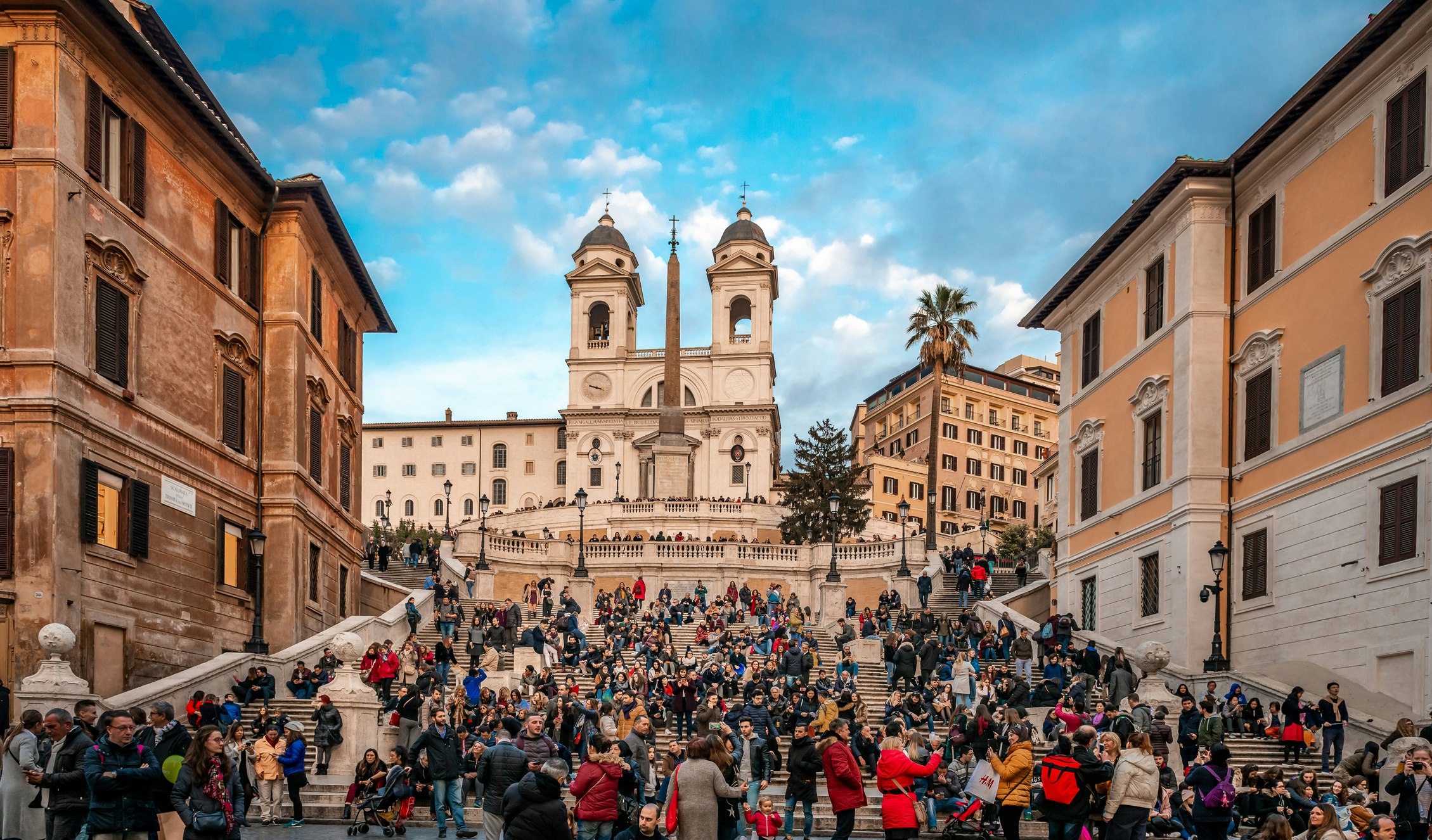 View of the crowded Spanish Steps with the church of the Santissima Trinita dei Monti and the Egyptian obelisk in the background.